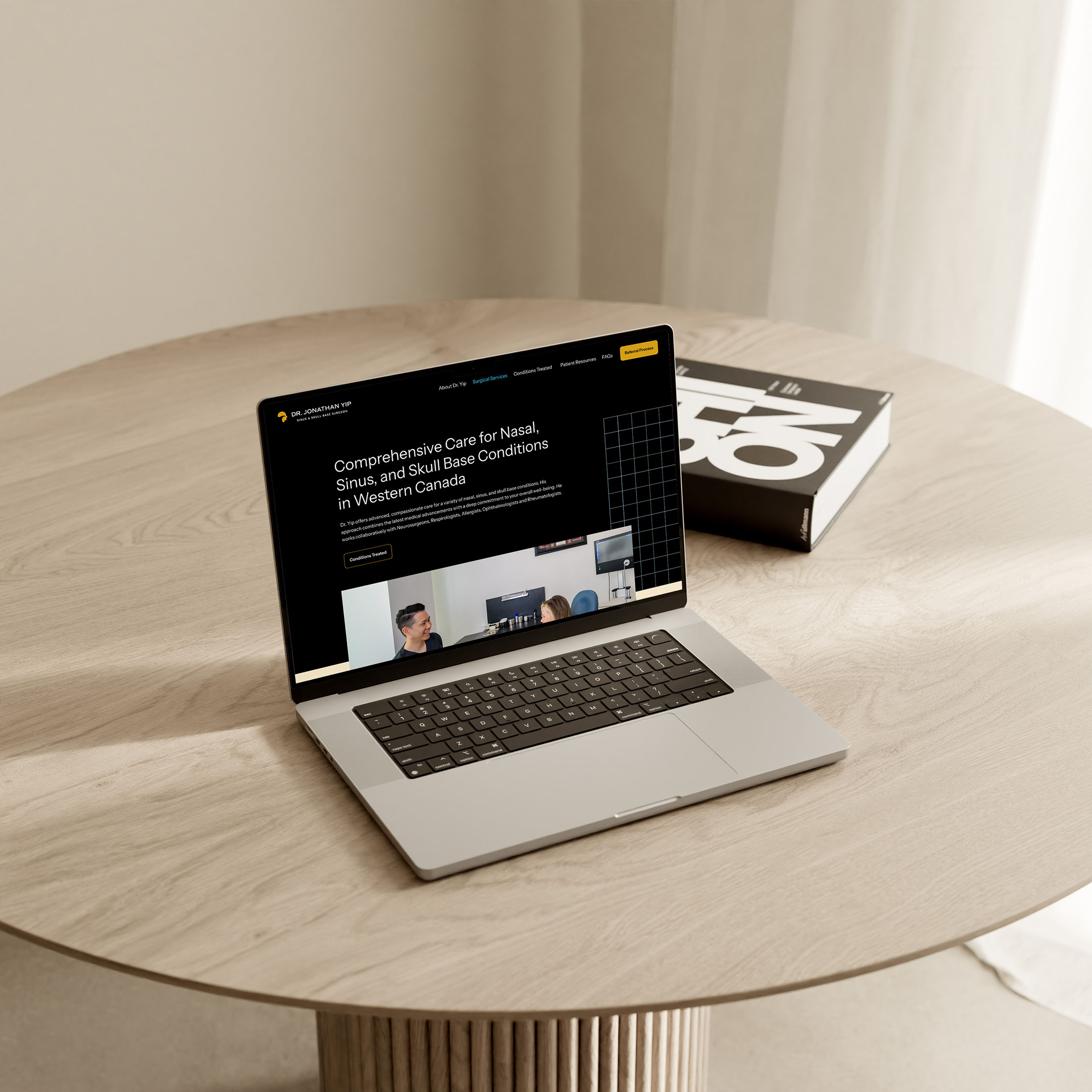 A laptop displaying Dr. Jonathan Yip’s website on a light wood table, emphasizing a clean and professional web design for medical services.