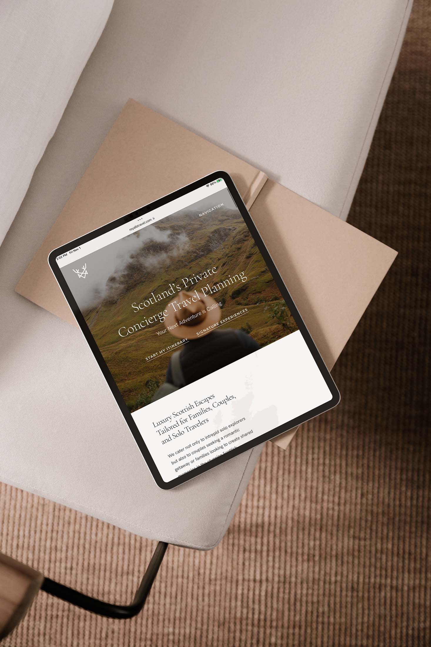 Royal B Travel website homepage displayed on a tablet, showcasing private concierge travel planning with a scenic Highlands background and luxury offerings.