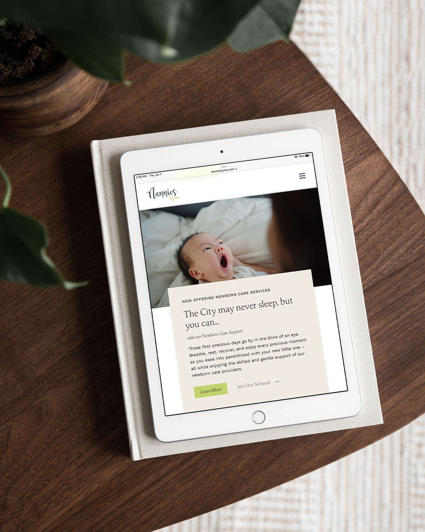 Tablet showing the Nannies by Noa homepage featuring their newborn care services message and emphasis on supporting parents during early parenthood.