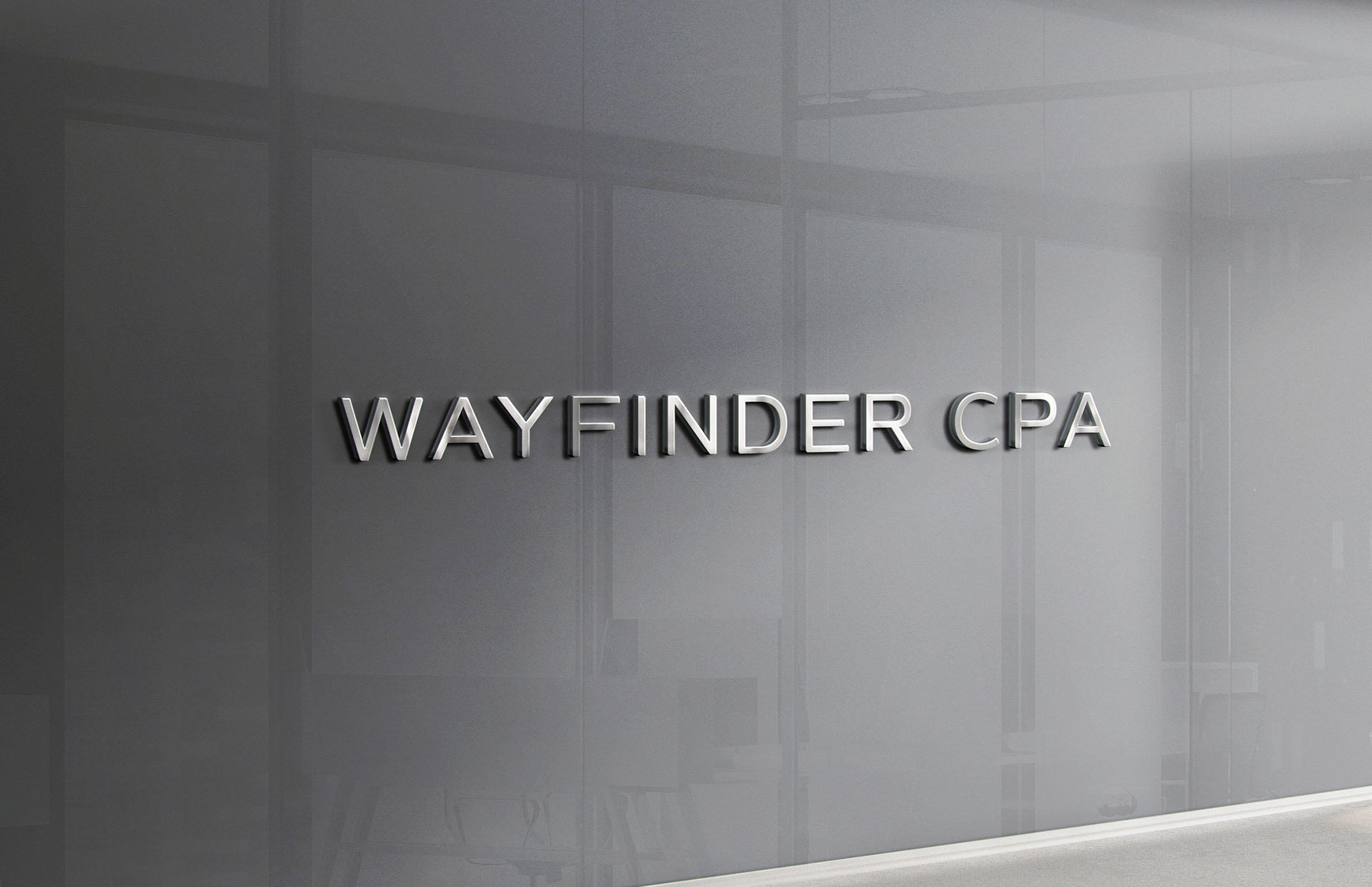 Metallic Wayfinder CPA logo mounted on a sleek, modern glass office wall, reflecting a professional and contemporary identity.