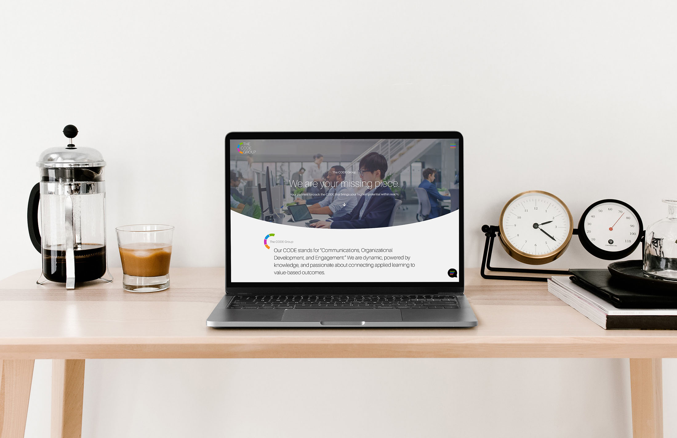 The CODE Group homepage displayed on a sleek laptop setup, showcasing their professional brand identity and modern digital presence.