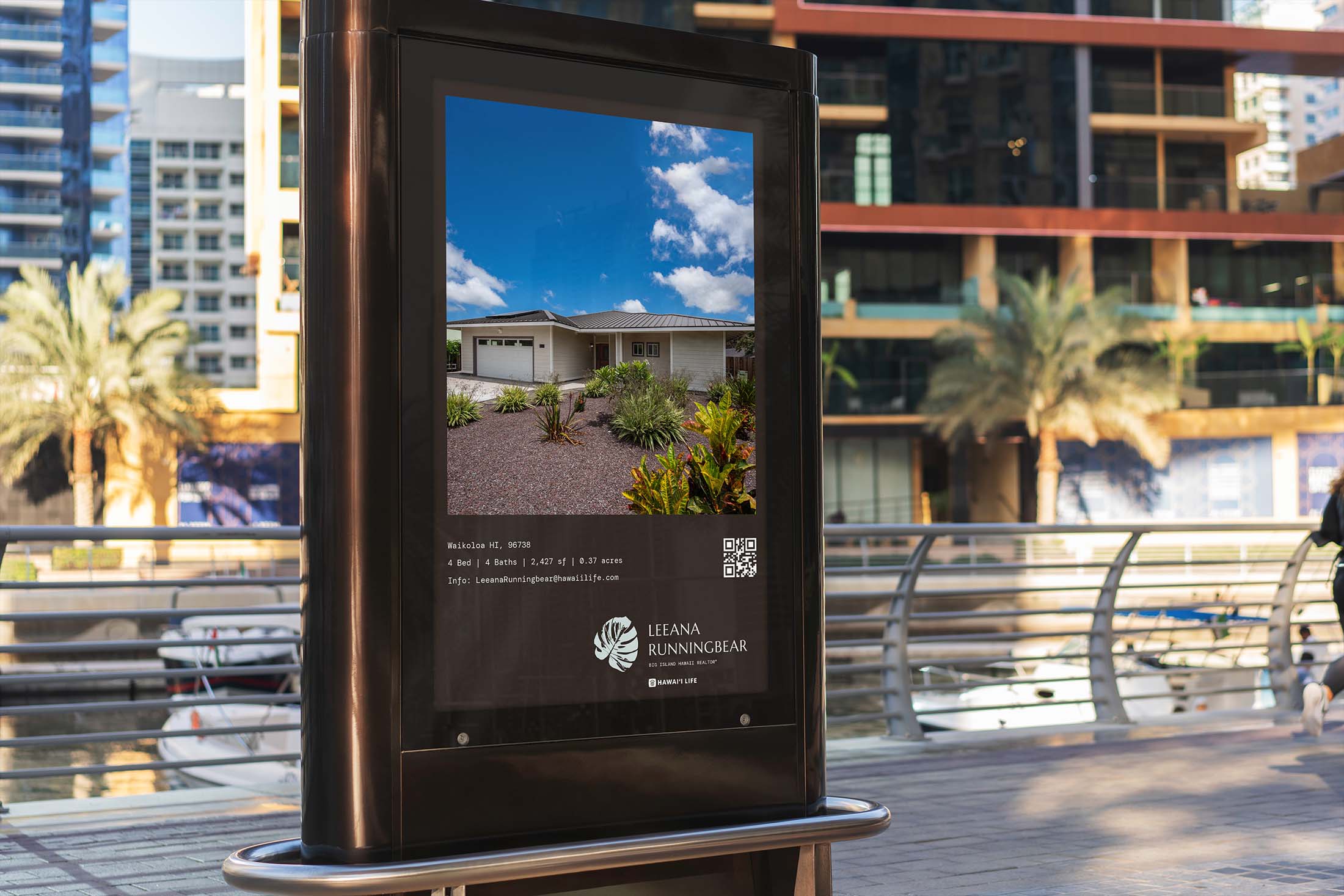 A digital billboard advertisement displaying a luxury Hawaiian home for sale by Leeana Runningbear Realtor®, with detailed property specifications and QR code for direct inquiries, set against an urban marina backdrop.