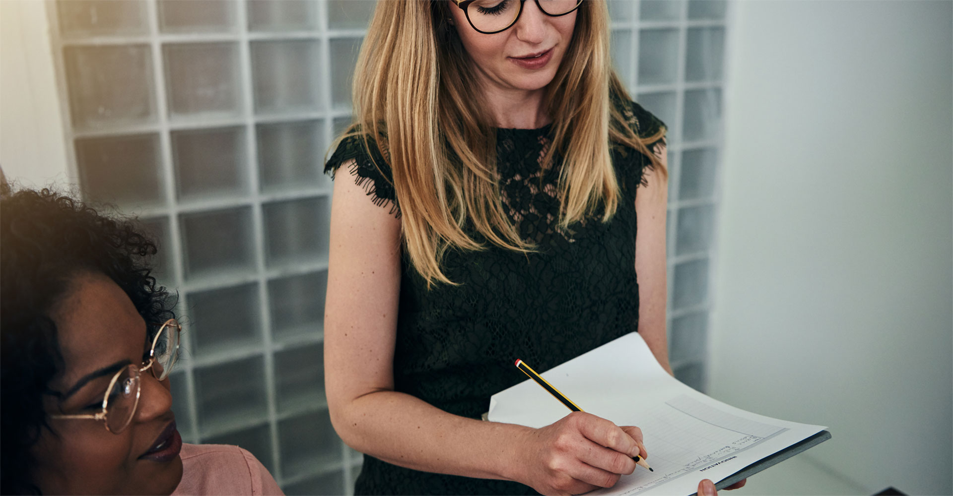 Professional woman taking notes during a collaborative meeting, emphasizing the process of working with a copywriter for effective branding and website content development.