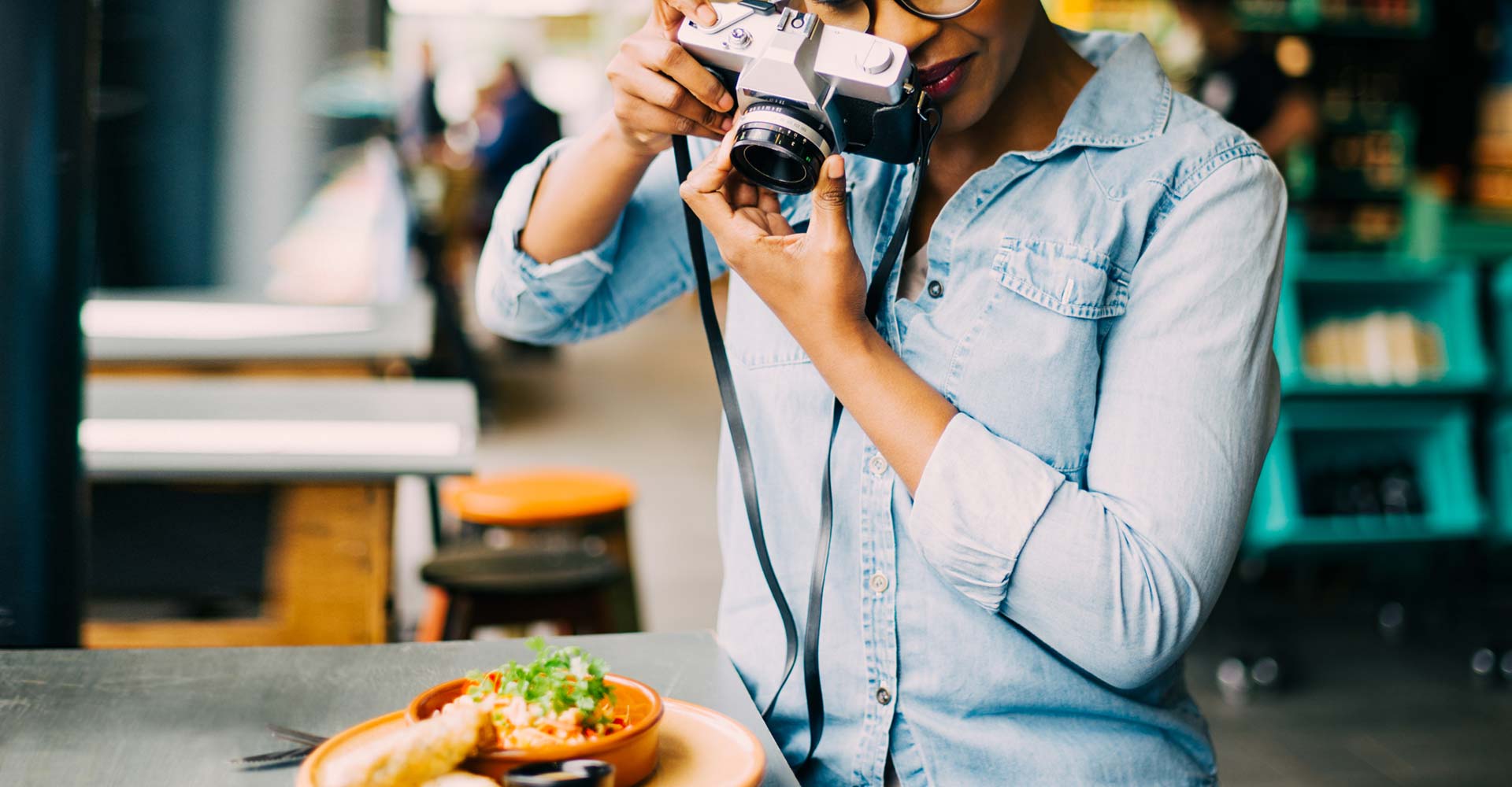 Creative professional photographing a plated meal in a vibrant setting, illustrating the importance of brand photography for storytelling and visual identity.