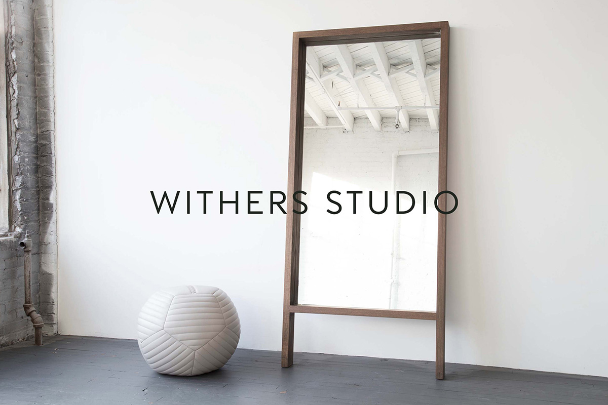 Floor-length mirror with wooden frame in Withers Studio, showcasing minimalist design and branding elements in a clean, modern interior setting.