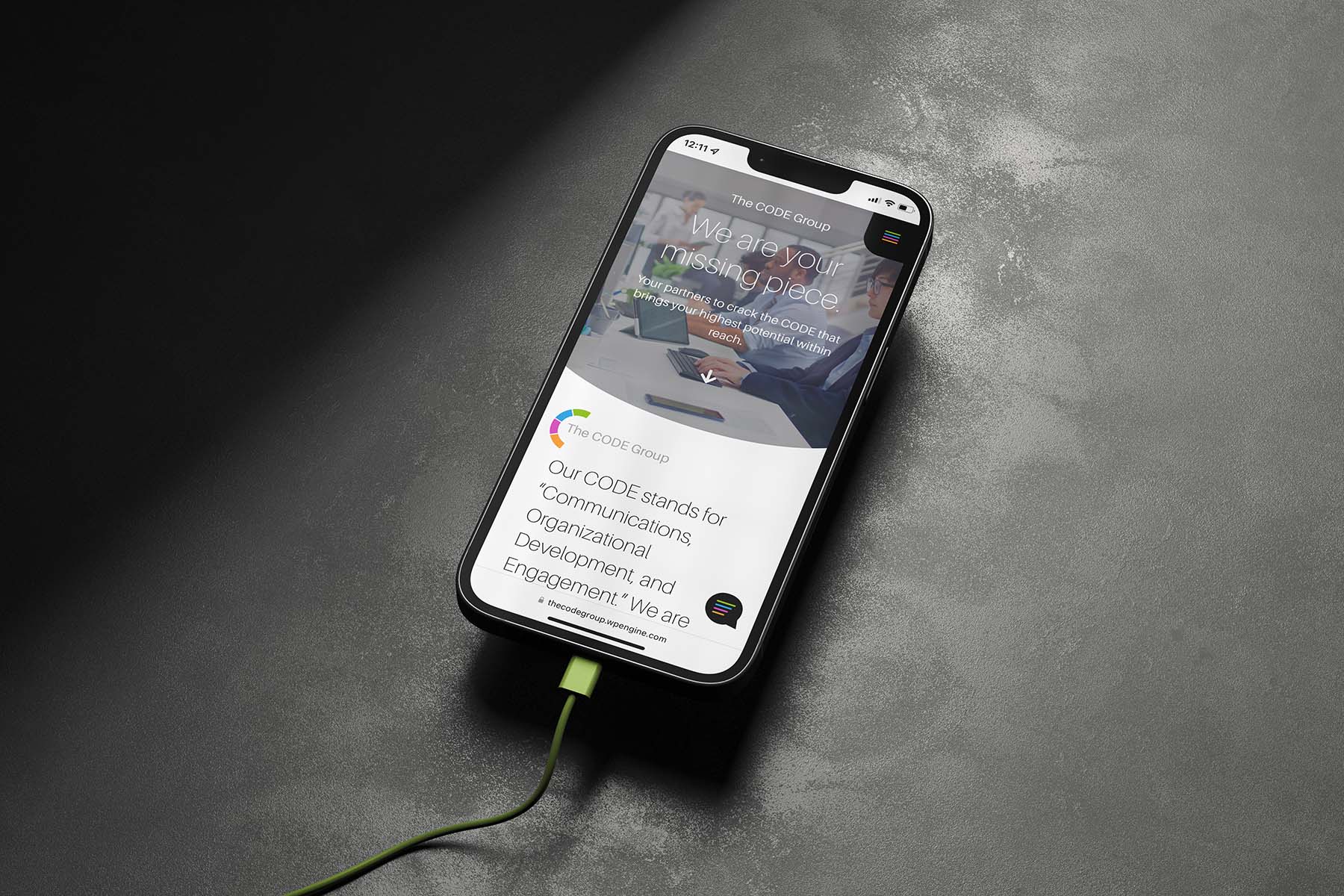 Mobile mockup displaying The CODE Group’s website homepage with the tagline “We are your missing piece” and a dynamic visual interface.