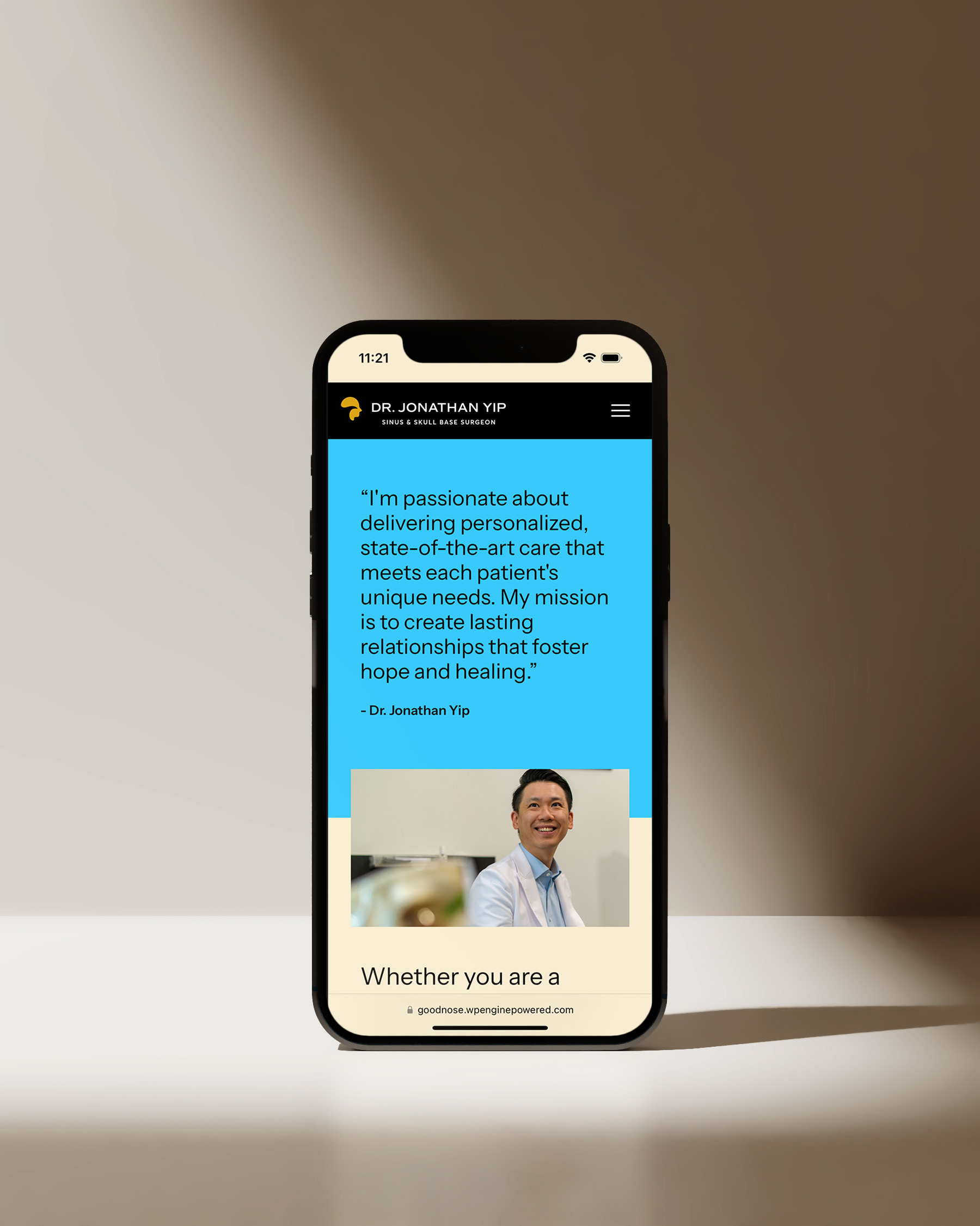 A smartphone displaying a website interface with a professional design, showcasing Dr. Jonathan Yip’s profile and a quote about delivering personalized care, set against a modern beige background.