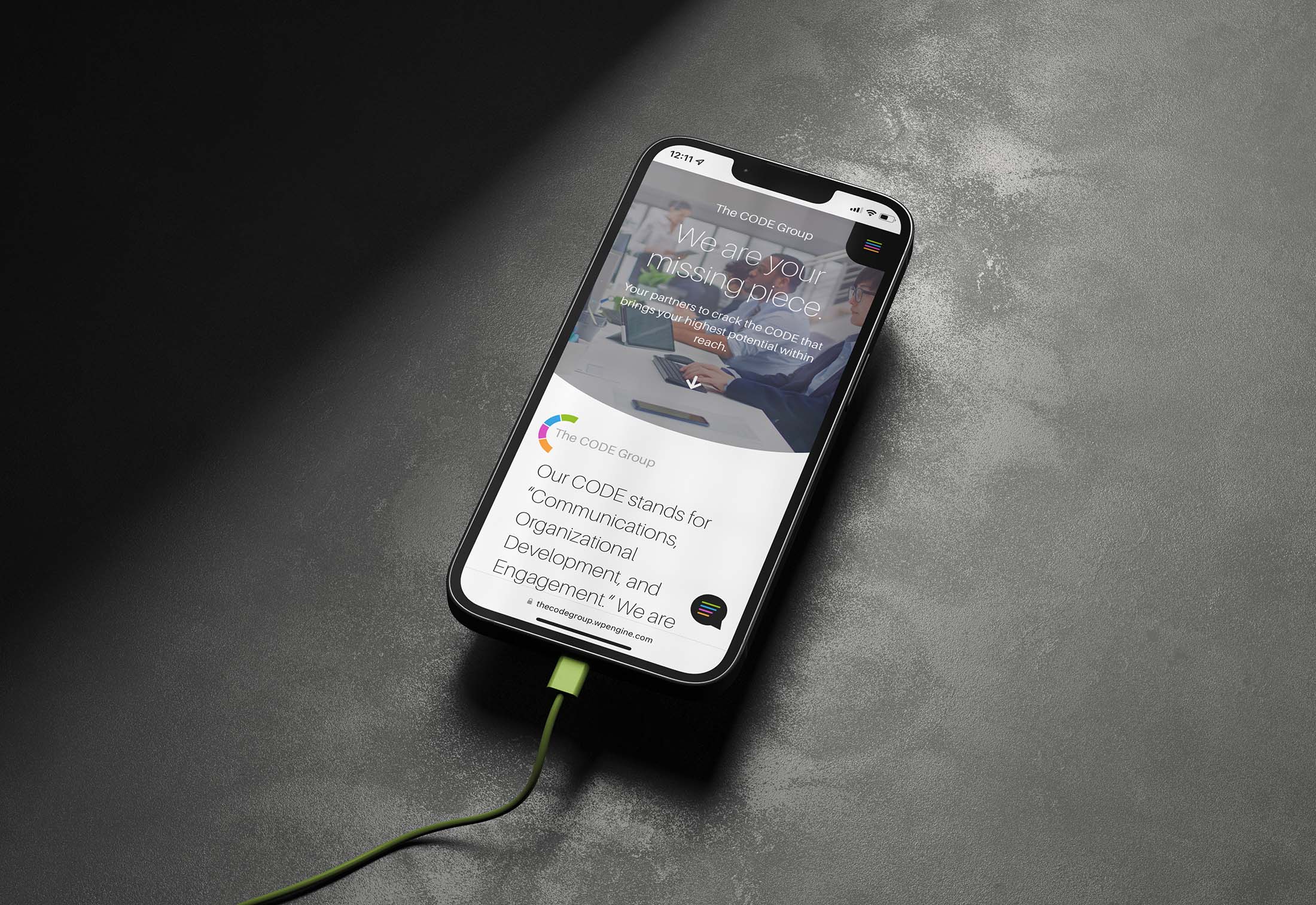 Mobile mockup displaying The CODE Group’s website homepage with the tagline “We are your missing piece” and a dynamic visual interface.