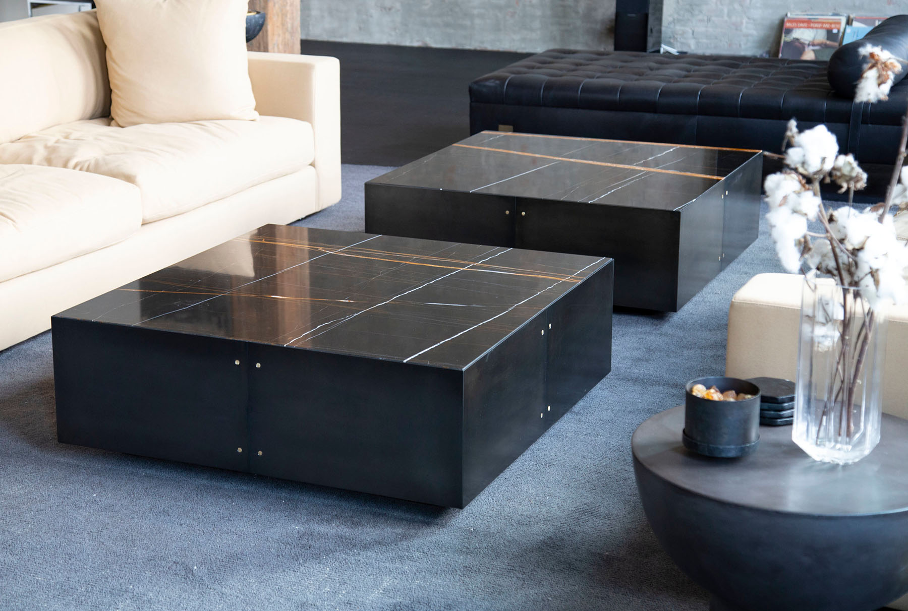 Modern black marble coffee tables designed by Withers Studio, featuring sleek lines and subtle logo-inspired detailing to emphasize branded craftsmanship.