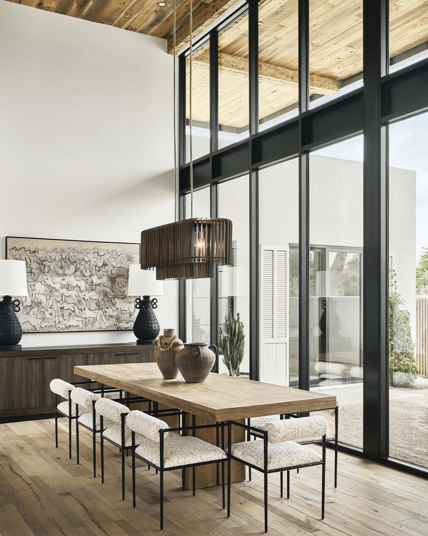 Luxurious dining room with high ceilings, natural light, and a custom wooden table from Modern Nest Homes’ portfolio.