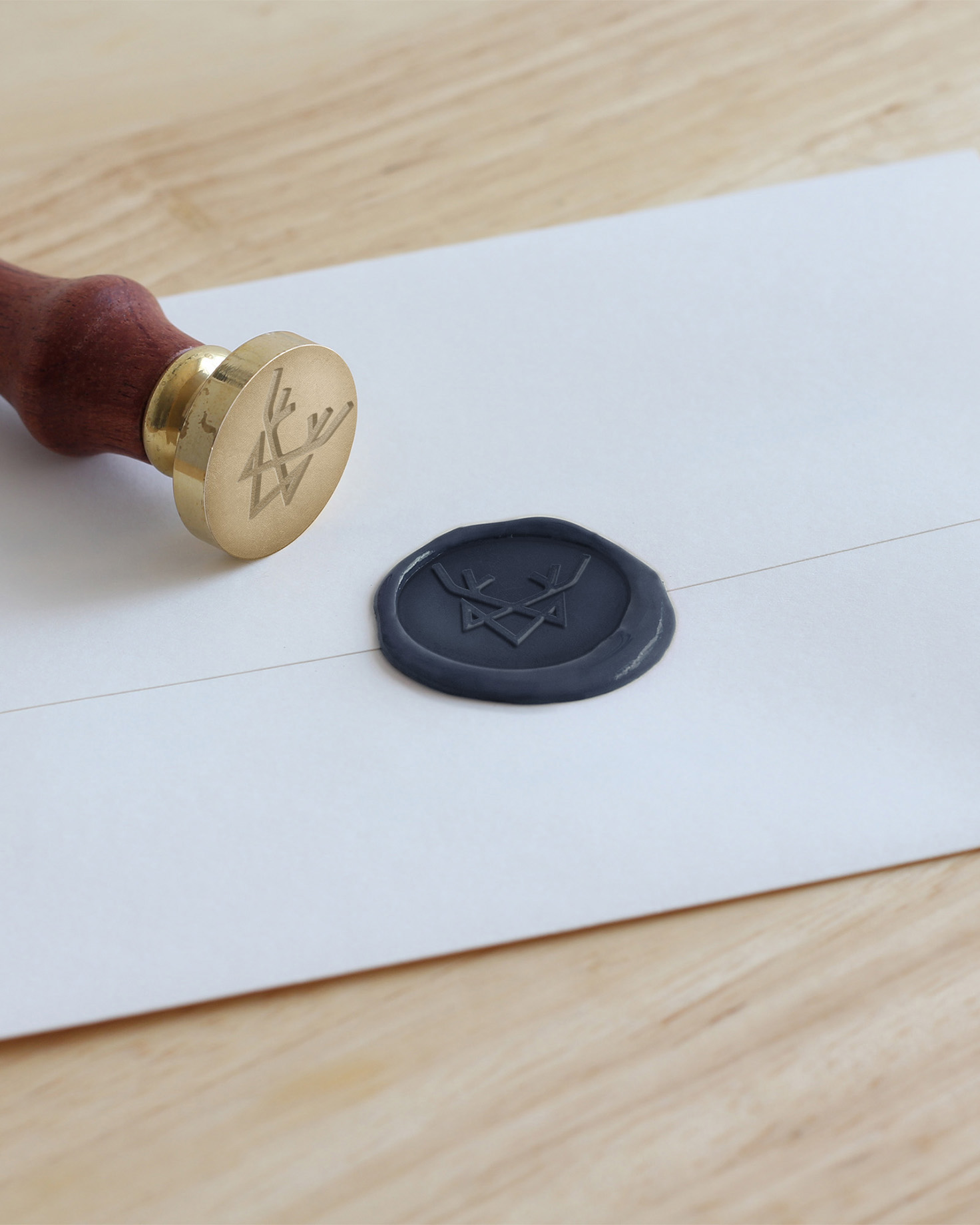 Royal B Travel custom wax seal and gold stamp featuring the brand logo, displayed on a white envelope on a wooden surface.