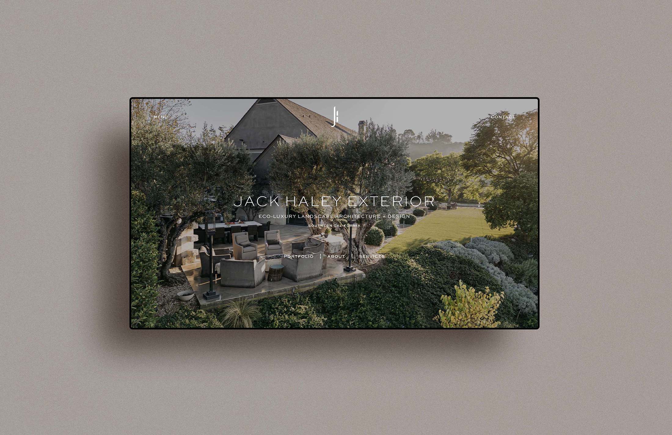 Jack Haley Exterior website displayed on a tablet with a scenic garden view showcasing luxurious outdoor seating and greenery.