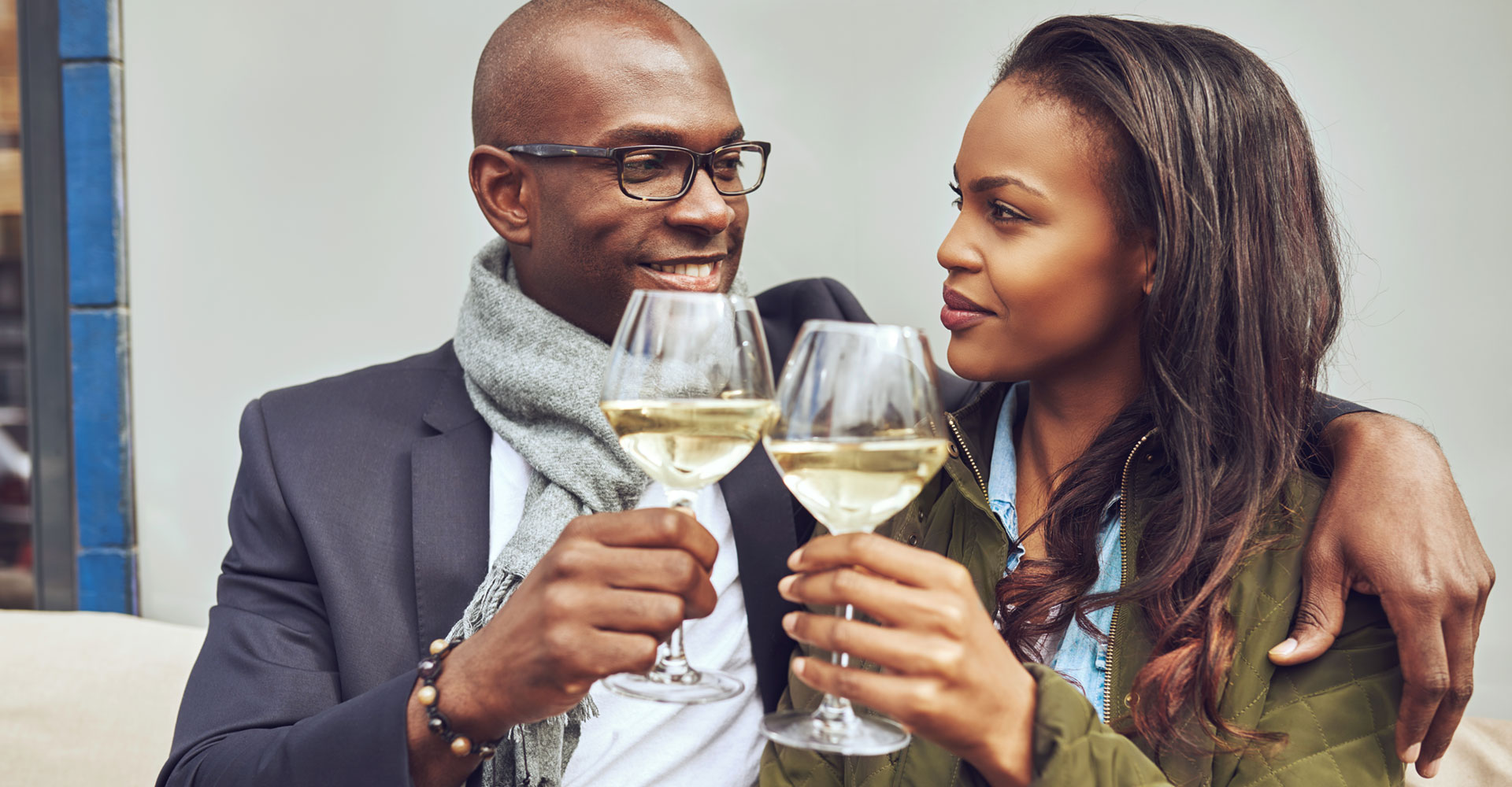 Smiling couple toasting with wine glasses, symbolizing the concept of branding for two audiences and creating connections through shared experiences.