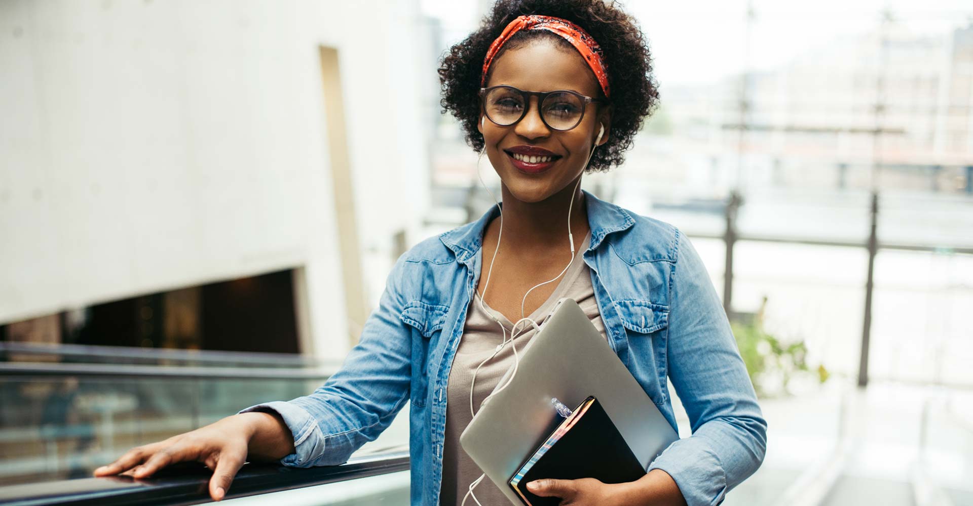 Confident young professional holding a laptop and notebook, symbolizing tips and strategies for new startups to build their brand and achieve success.