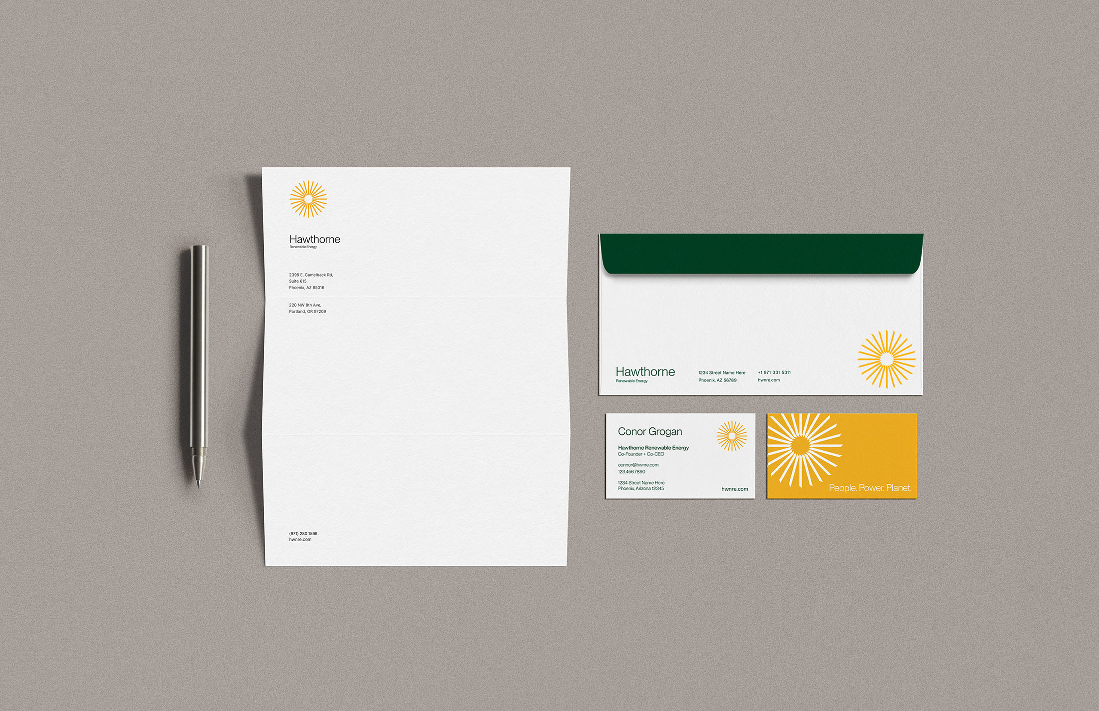 Hawthorne Renewable Energy branded stationery set featuring a letterhead, envelope, and business cards with the yellow sunburst logo and green accents.