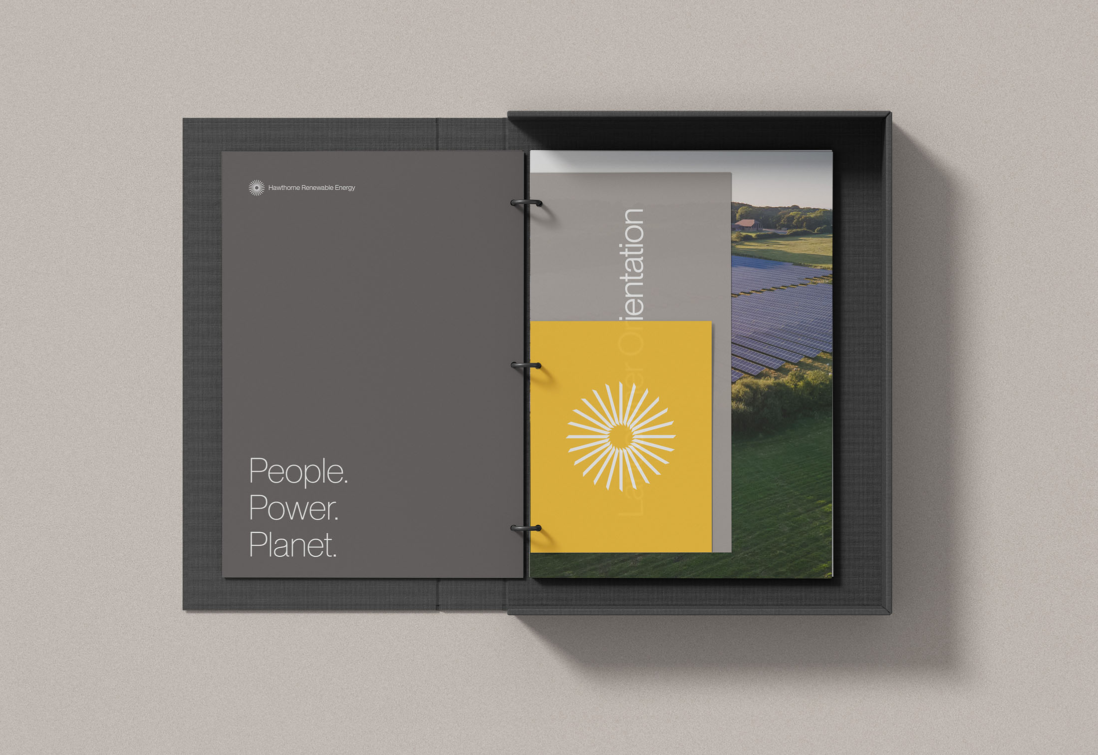 Hawthorne Renewable Energy branded folder featuring the tagline “People. Power. Planet.” on a dark gray cover with a yellow sunburst logo and documents inside showcasing a solar farm and corporate branding materials.