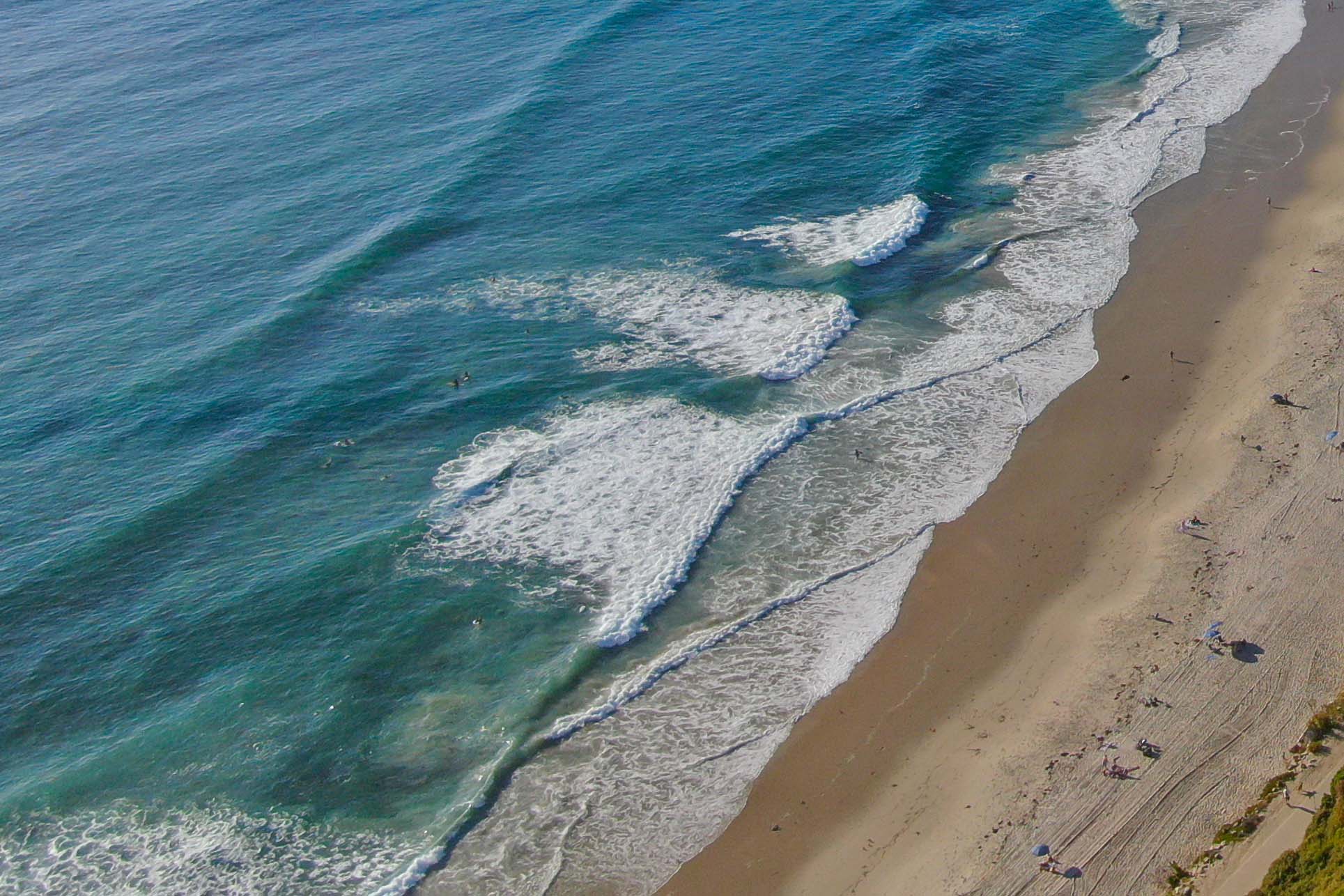 Close-up of waves breaking on a sandy beach, emphasizing natural beauty and tranquility as part of Salt Creek Partners’ branding.