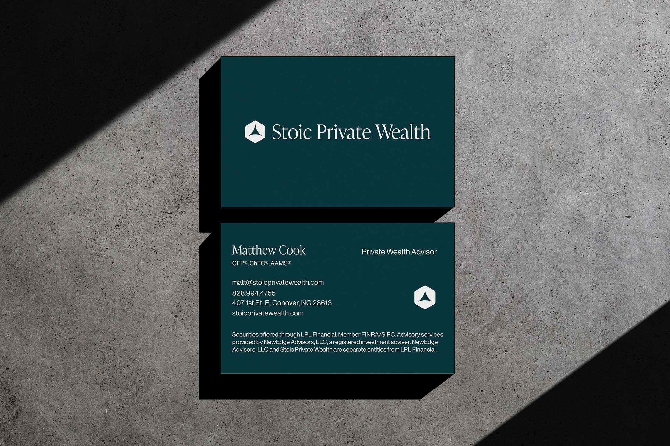 Stoic Private Wealth branded business cards featuring the geometric logo, company name, and advisor contact details on a dark green background.