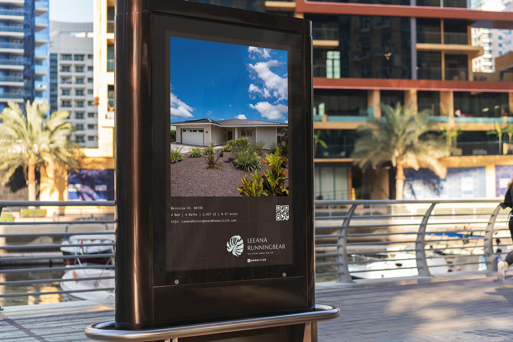 A digital billboard advertisement displaying a luxury Hawaiian home for sale by Leeana Runningbear Realtor®, with detailed property specifications and QR code for direct inquiries, set against an urban marina backdrop.