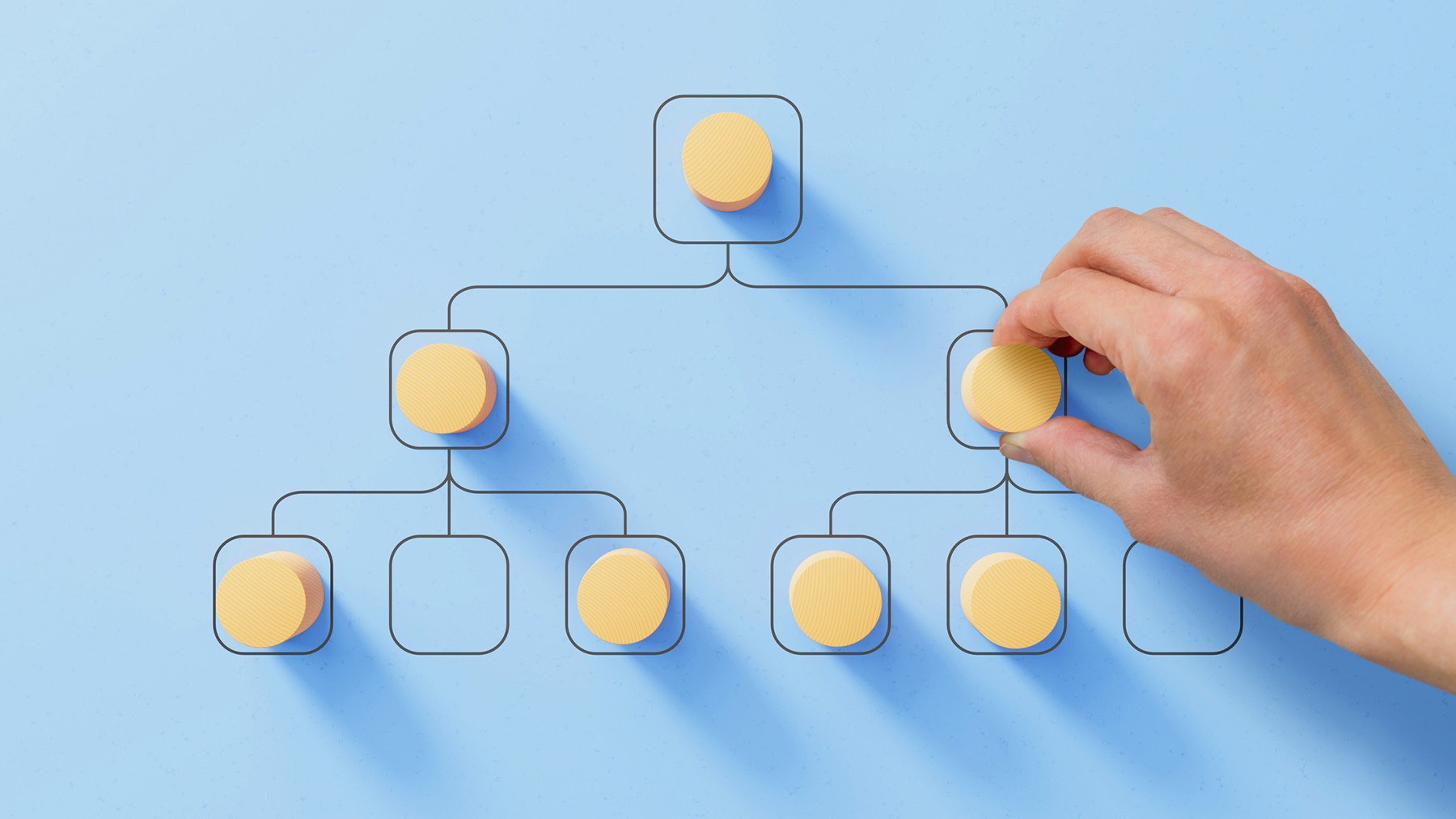 A hand arranging circular yellow tokens on a flowchart against a light blue background, symbolizing organization, strategy, and streamlined processes.