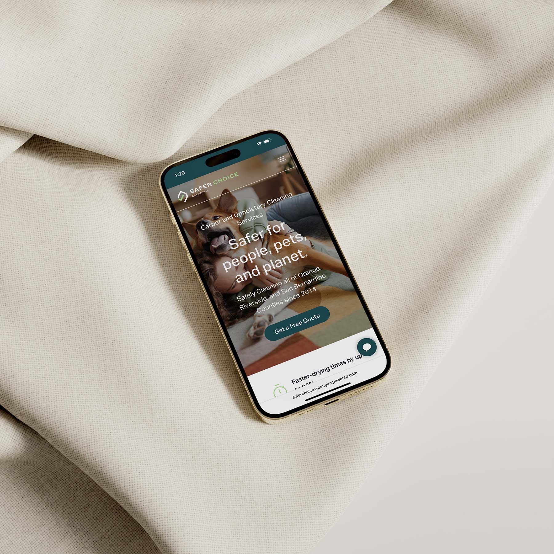 Smartphone displaying the Safer Choice Cleaning mobile website on a cream-colored fabric surface, featuring the homepage headline “Safer for people, pets, and planet” with a call-to-action button.