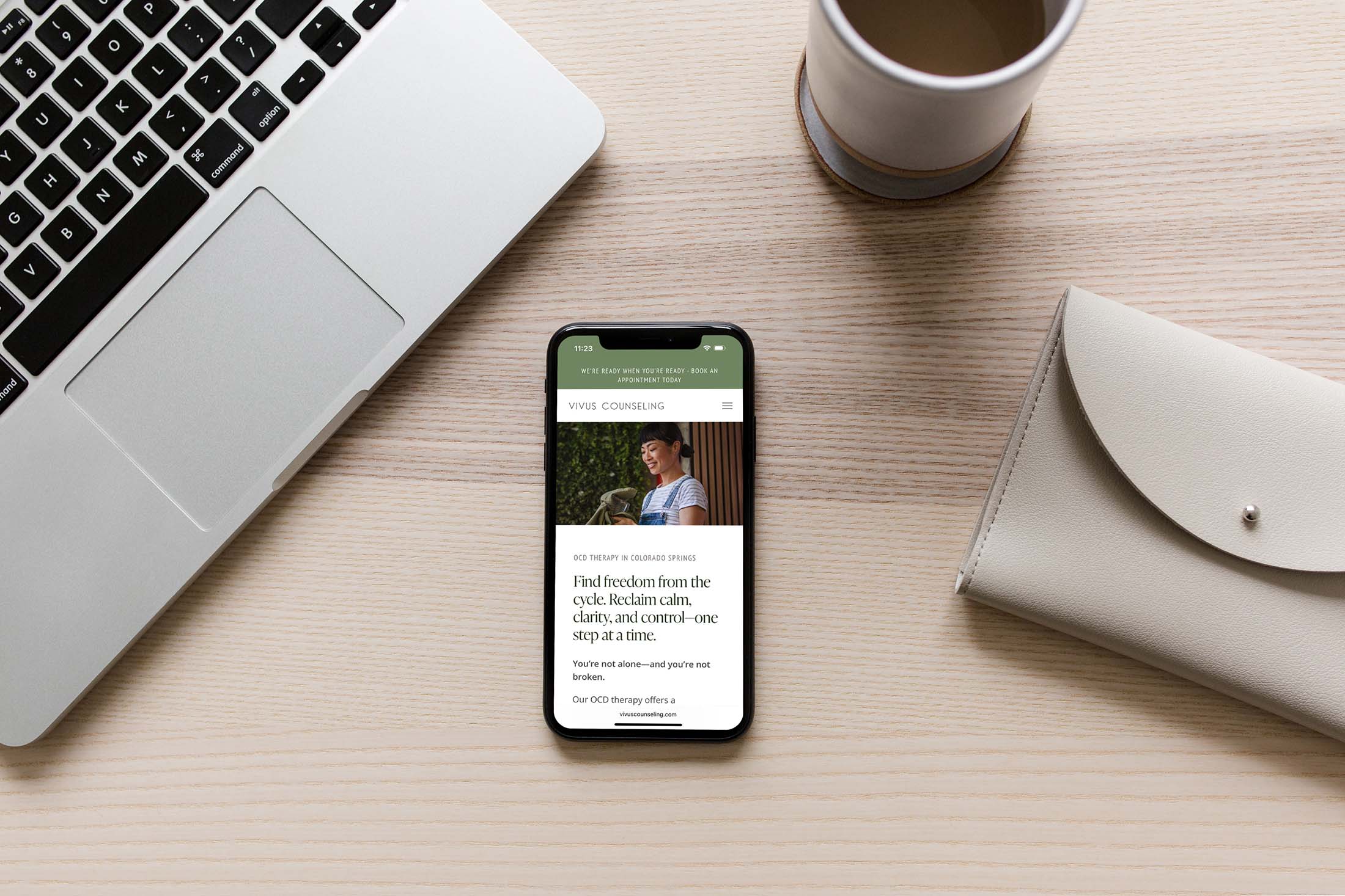 Vivus Counseling mobile site displayed on a phone beside a laptop and coffee, featuring OCD therapy support for calm and clarity.