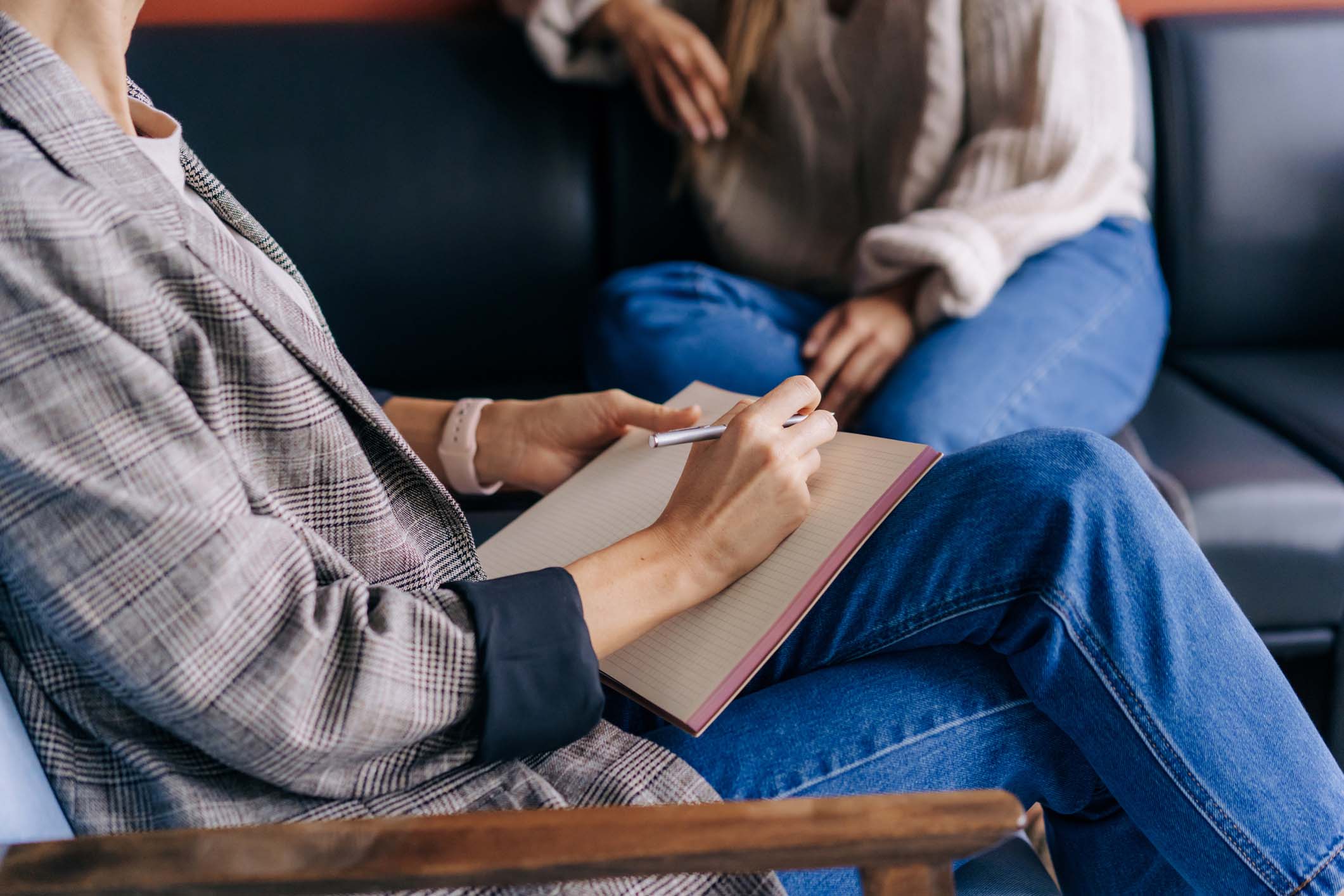 Close-up of counselor writing notes in a therapy session, symbolizing professional, personalized mental health care at Vivus Counseling.