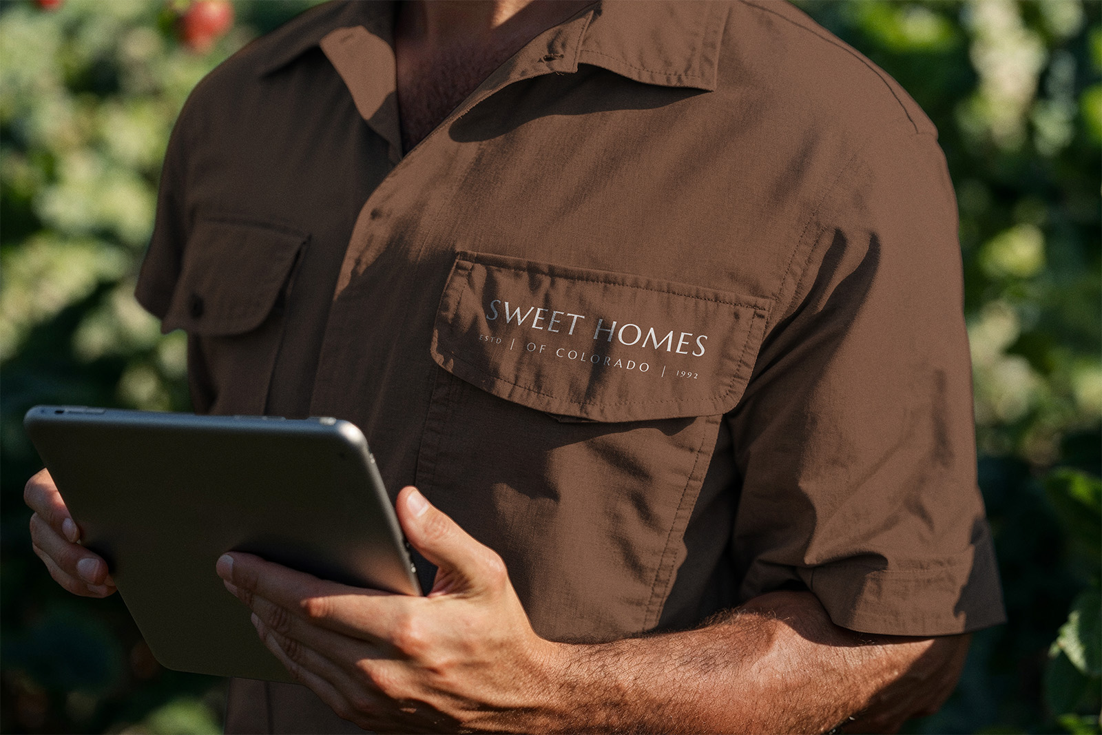 Sweet Homes of Colorado team member reviewing construction plans on a tablet at a job site