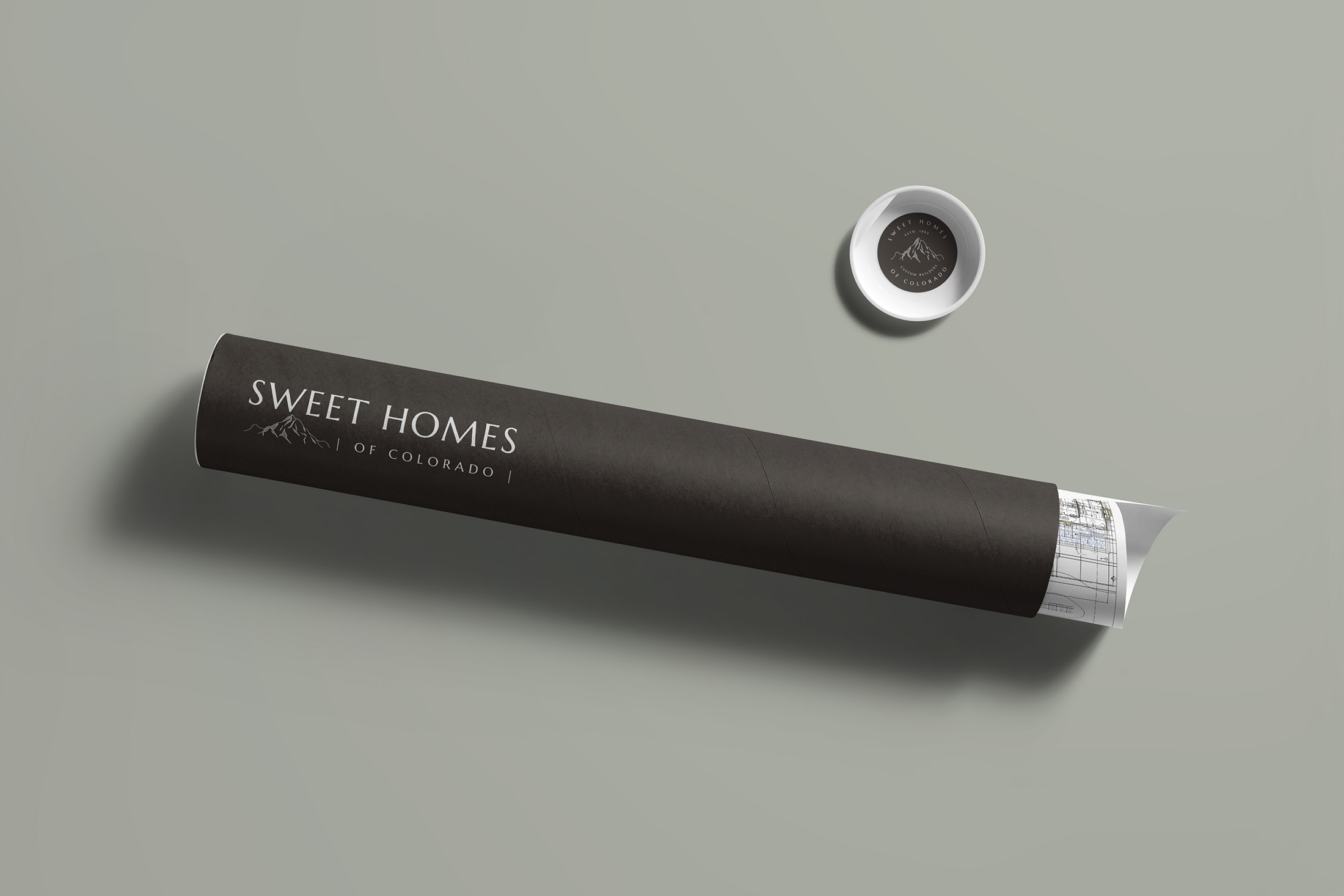 Rolled architectural blueprints with Sweet Homes of Colorado branding on a minimalist background